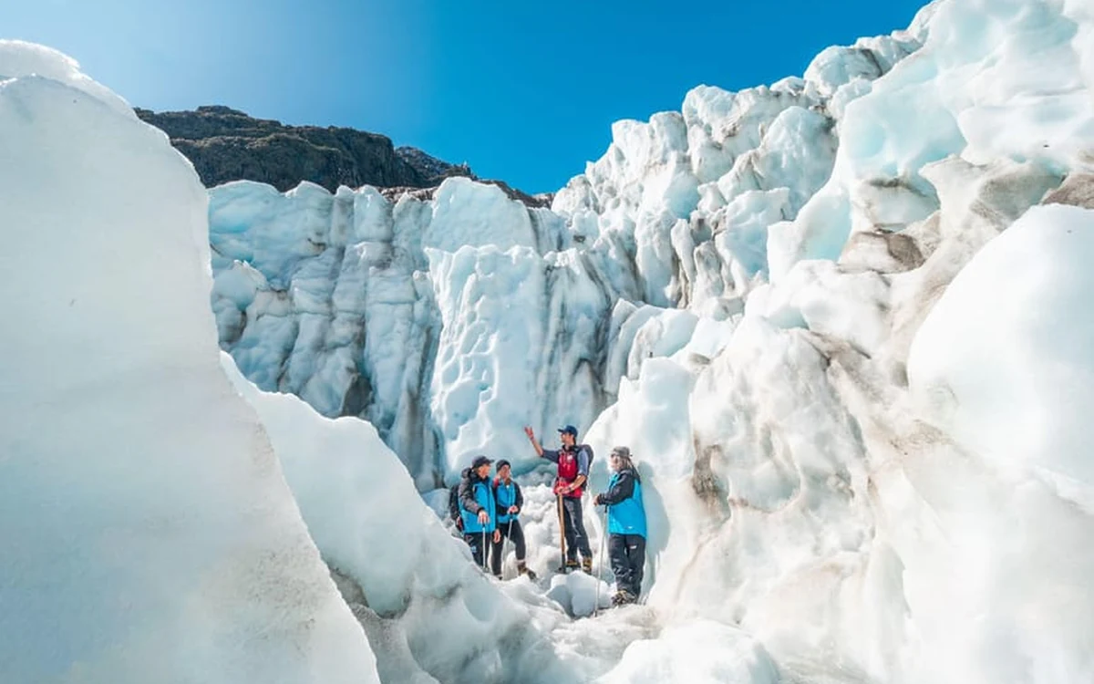 Mit Seil gesicherte Wanderer auf dem Fox Glacier nach der Hubschrauberlandung