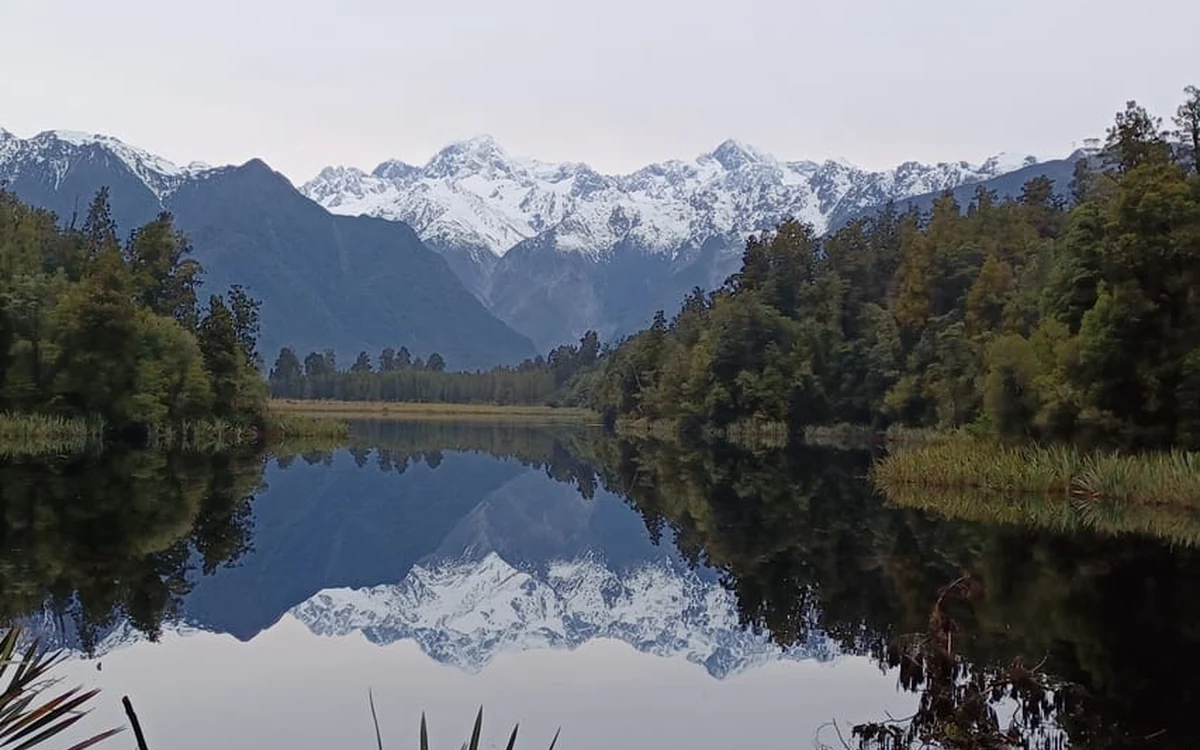 Lake Matheson at dawn with the Southern Alps reflected on the water